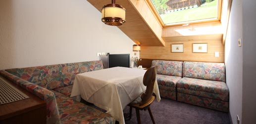 Wohnung 34: Wohnzimmer im Dachgeschoss mit Eckbank und Tisch