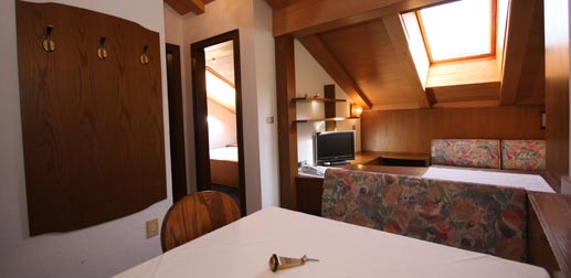 Wohnung 32: Wohnzimmer im Dachgeschoss mit Sofa, TV und Tisch