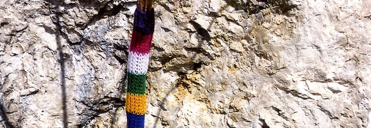 Pole wrapped in colourful knitting (guerrilla knitting)